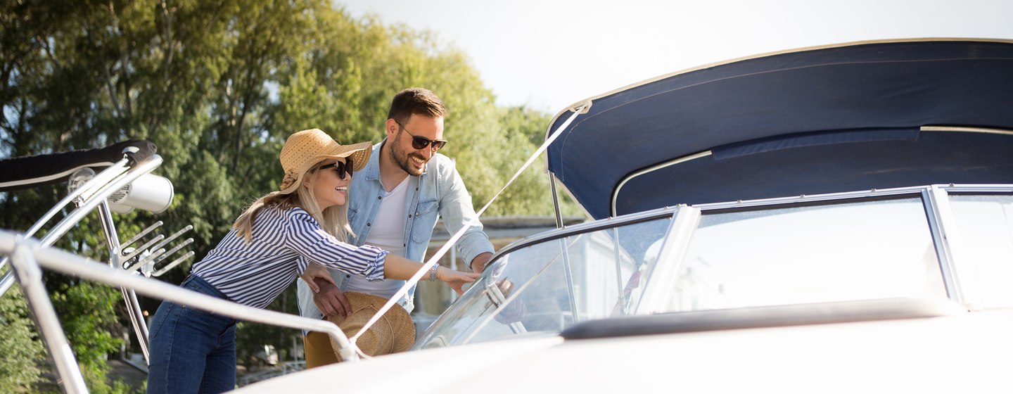 A beautiful young couple watches a motor boat that they intend to buy.