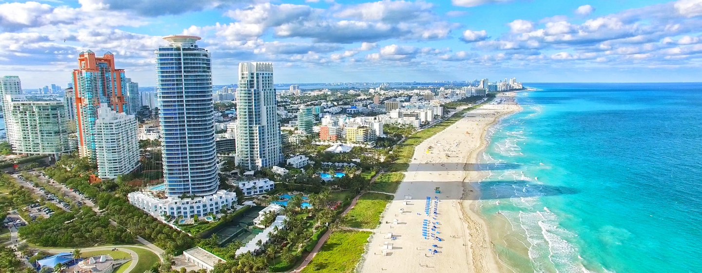 Overview of South Beach Florida, sandy coastline lined with towering hotels and azure waters.