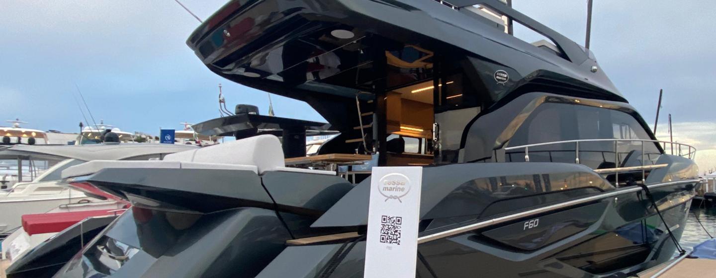 Sessa Marine F60 Flybridge yacht shown starboard side to dock, the images shows part of the aft deck bathing platform, and along the starboard side to bow in distance, blue sky