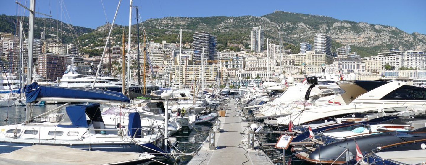 Monaco Yacht Show, harbour with lots of docked yachts, surrounded by marina facilities and cliff face