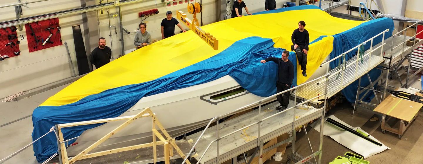  Windy Boats SR53 Tender under construction with workers on top and yellow and blue sheet covering 