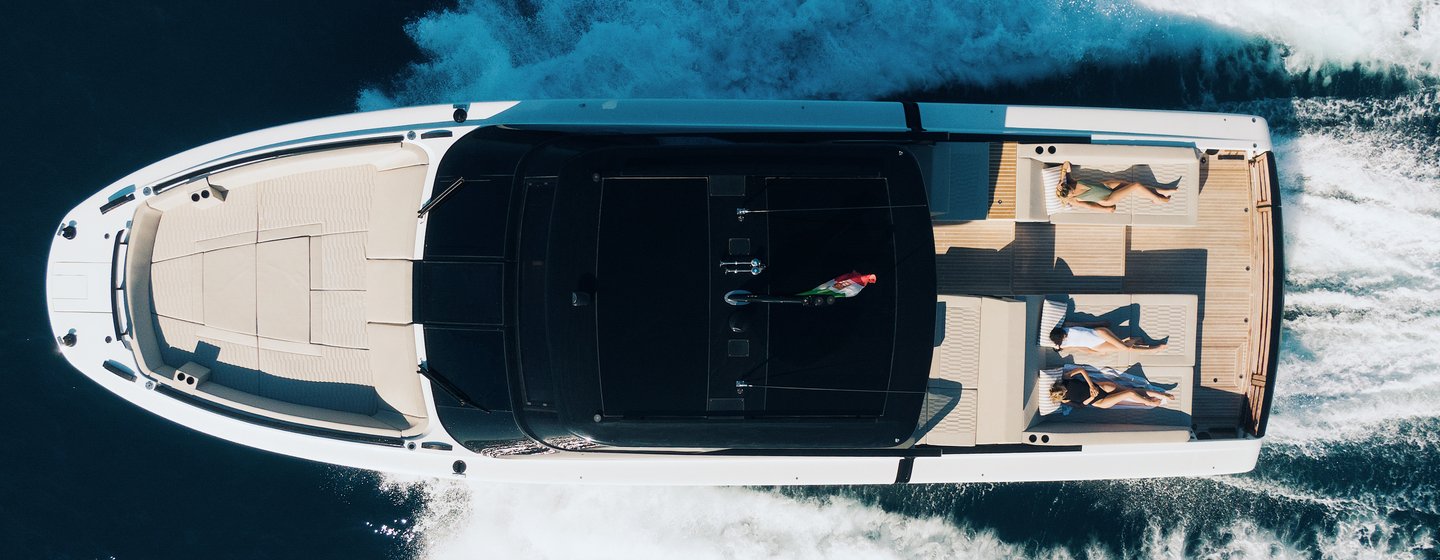 A top-down view of the Fiart Yachts P58 charging through a calm sea with guests on the sun pads enjoying the on-water experience