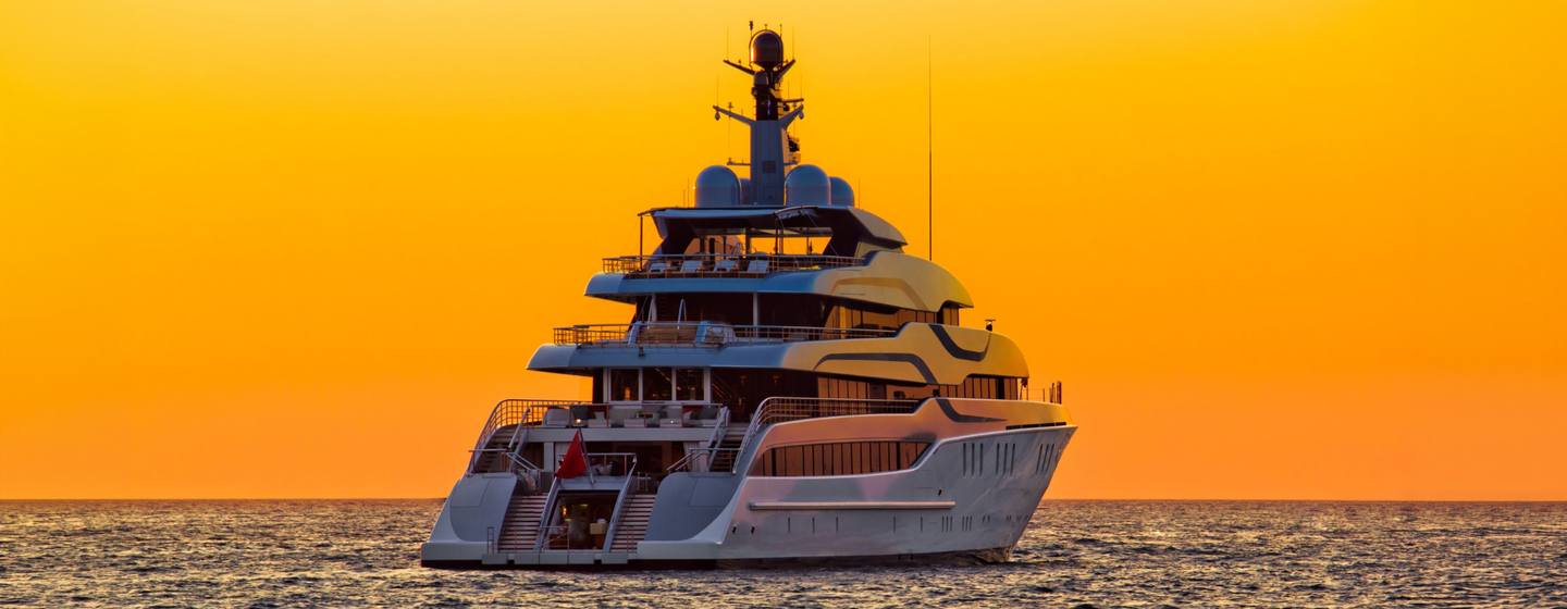 Superyacht at anchor with a sunset 