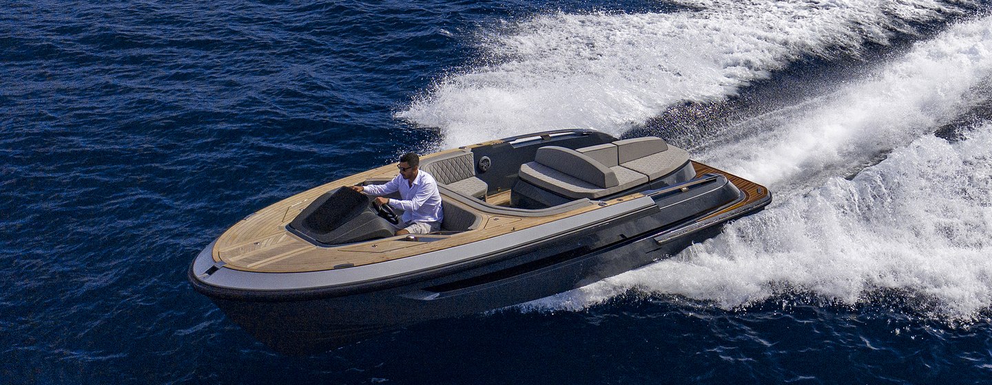 Evo T2 Tender moving at speed on sea with spray behind and man at helm