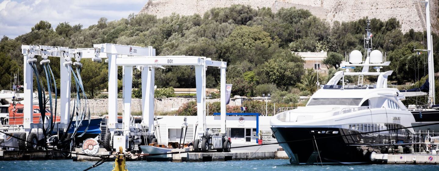 Overview of Monaco Marine Antibes, motoryacht moored adjacent to lift, with old town in background