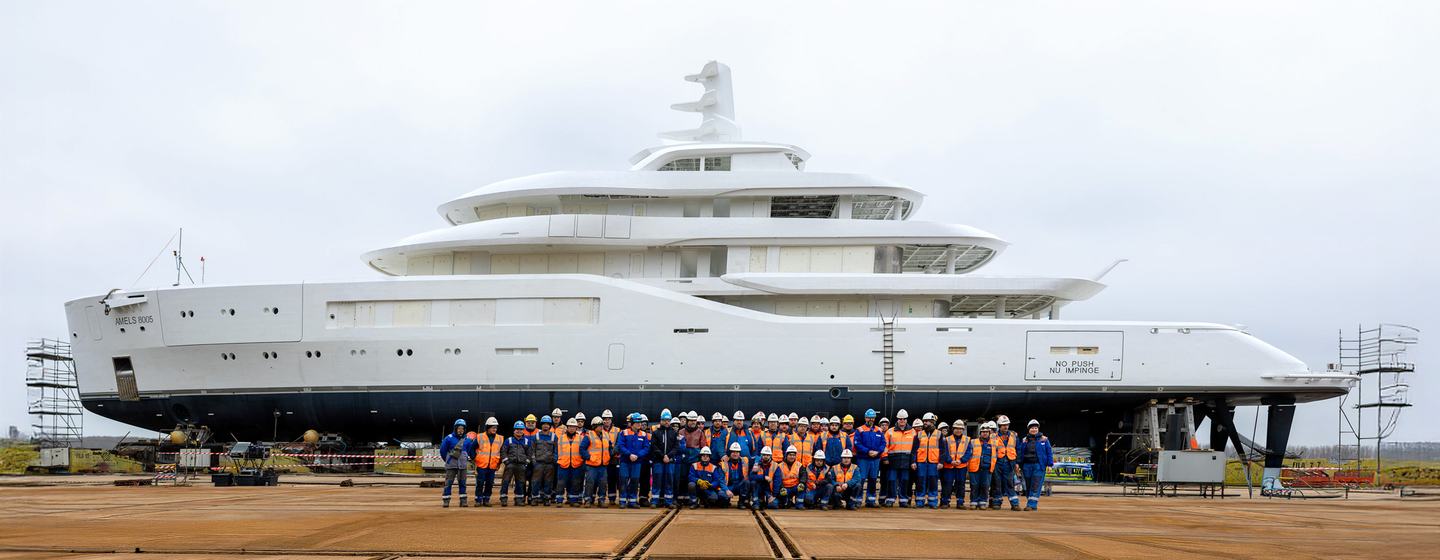 Workers in front of Fifth Amels 80 superyacht at launch