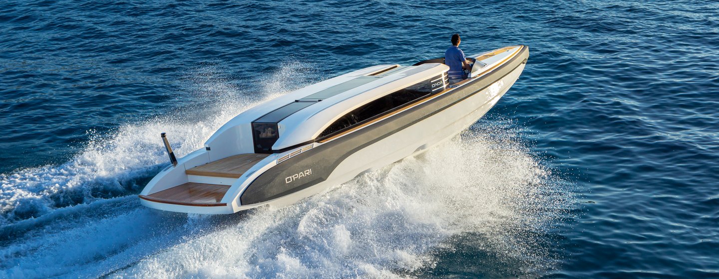 Onda 31L limousine tender on sea with person at helm and waves spraying either side