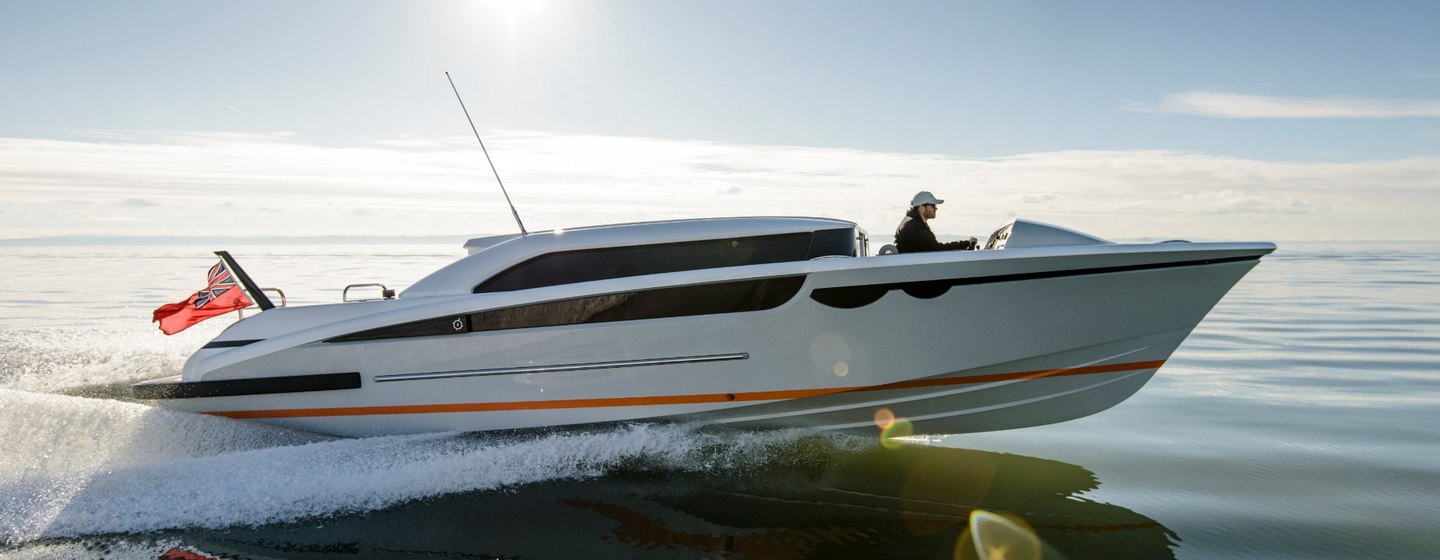 Limousine tender viewed from side at sunset with man at helm, and tender moving at speed