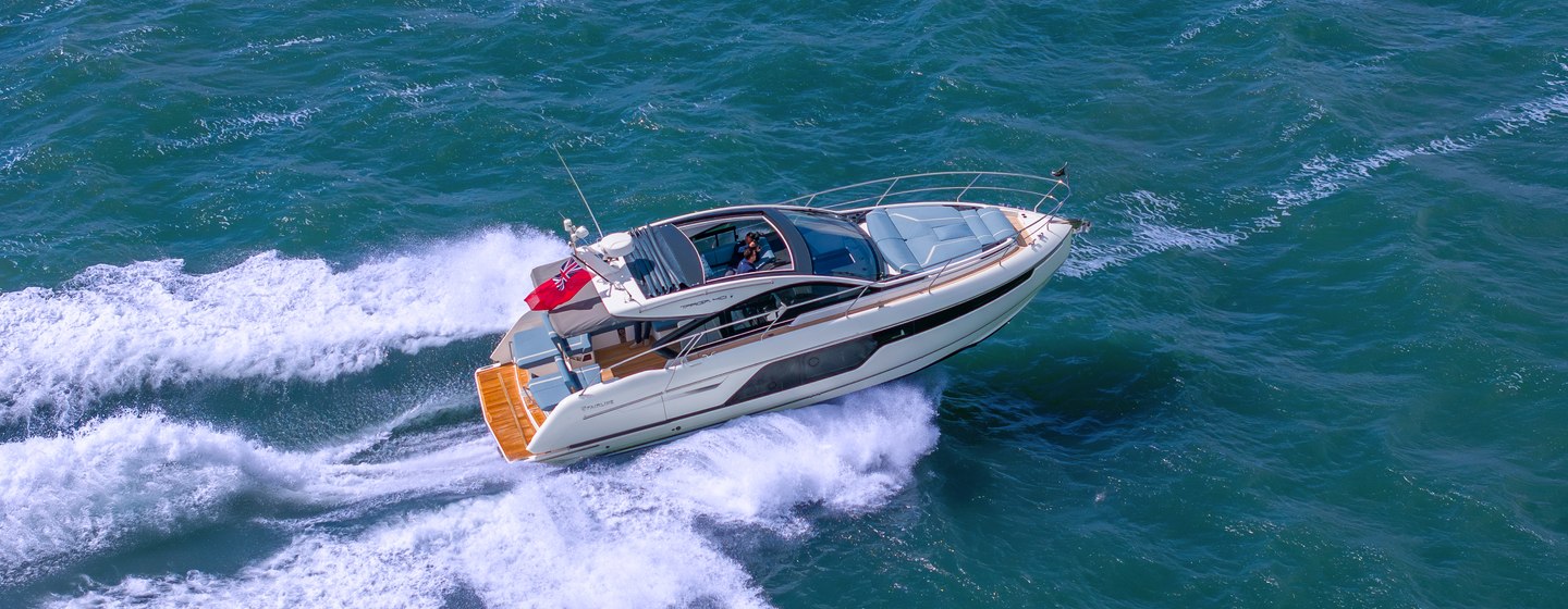 Fairline Targa 40 shown in aerial running shot starboard side profile, making way at speed in calm sea in daylight