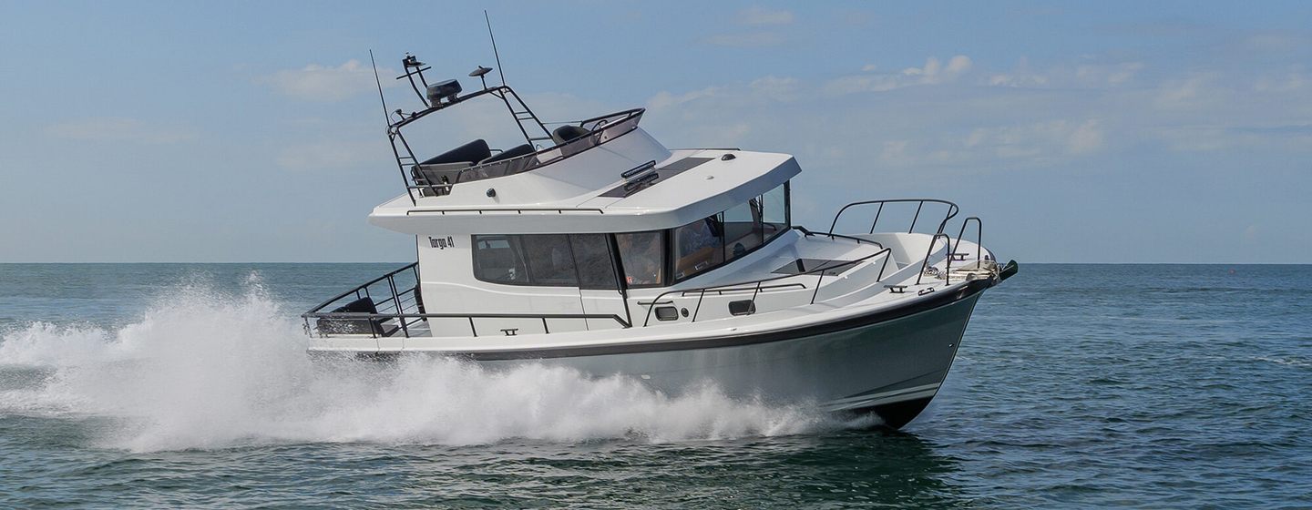 Targa 41 motor boat running shot starboard bow and side profile, on heel so making way at speed, calm sea, bright day