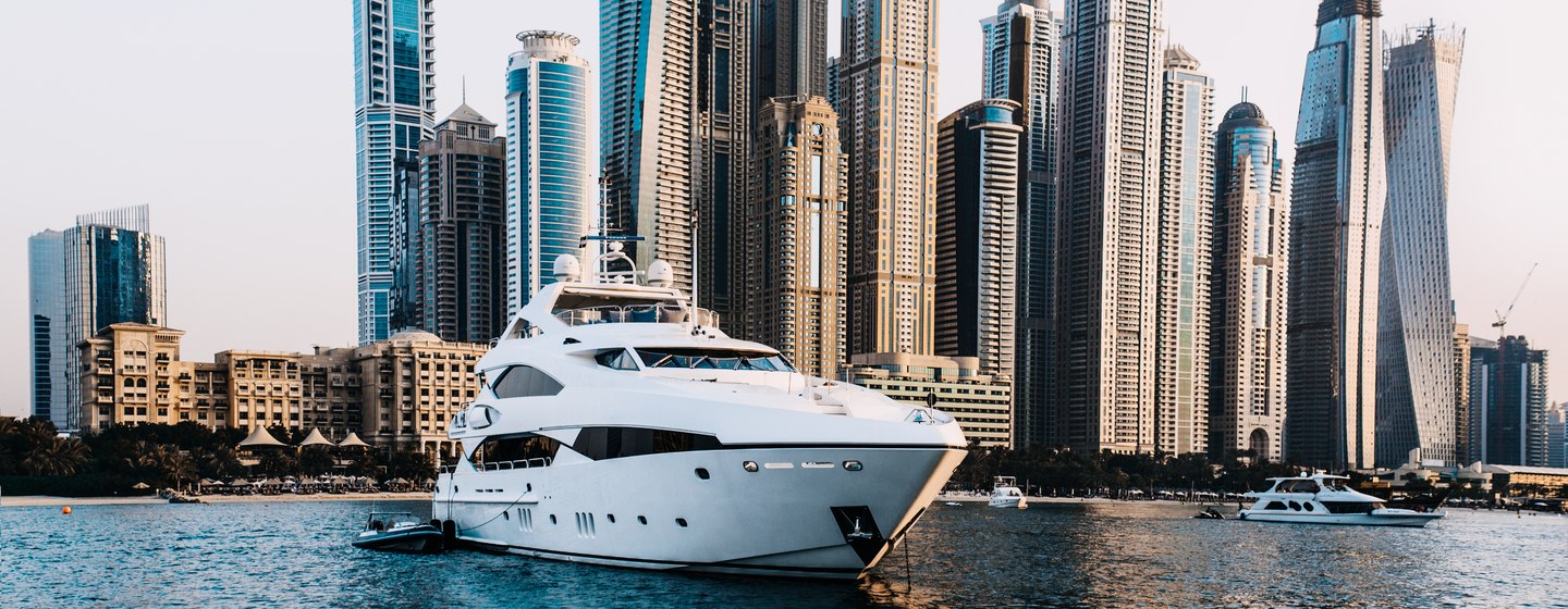 The yacht against the background of skyscrapers floats. Dubai