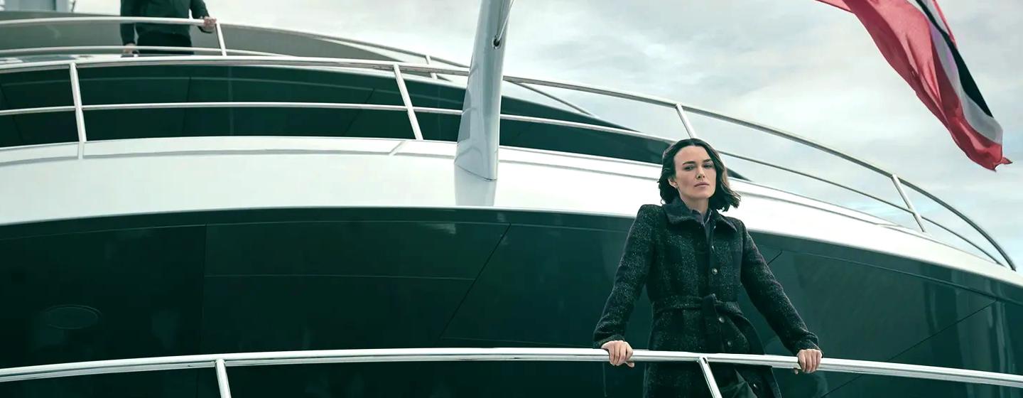 Keira Knightley standing on superyacht Savannah deck underneath Norway Flag