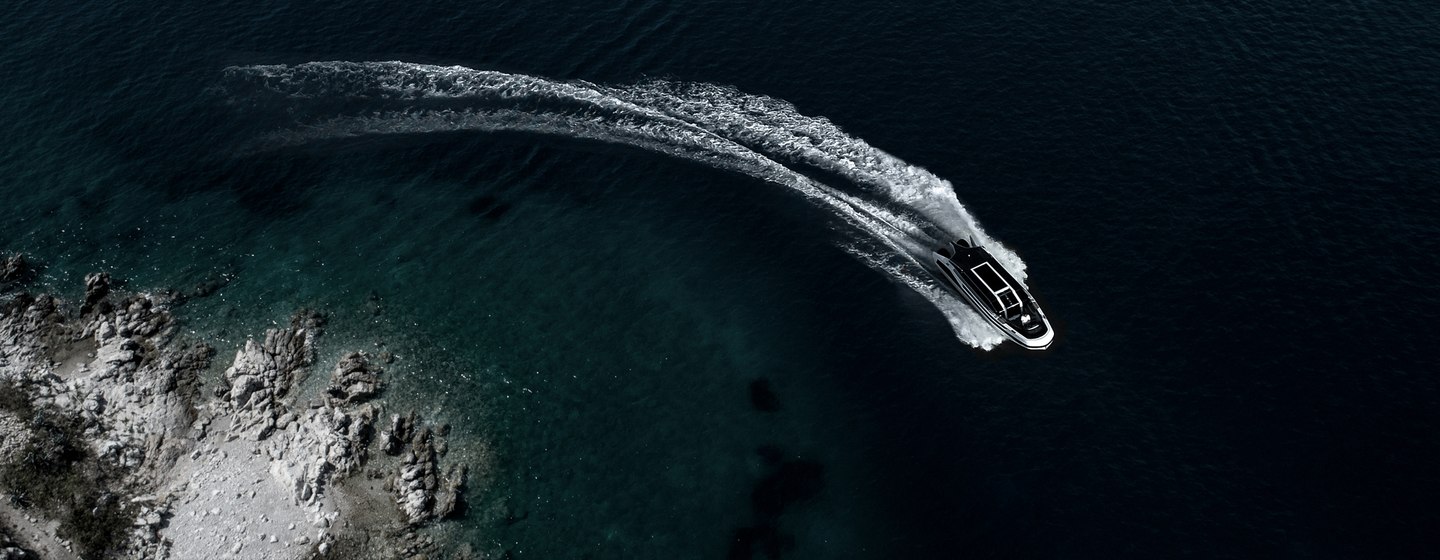 Limousine tender with sea spray behind in clear water