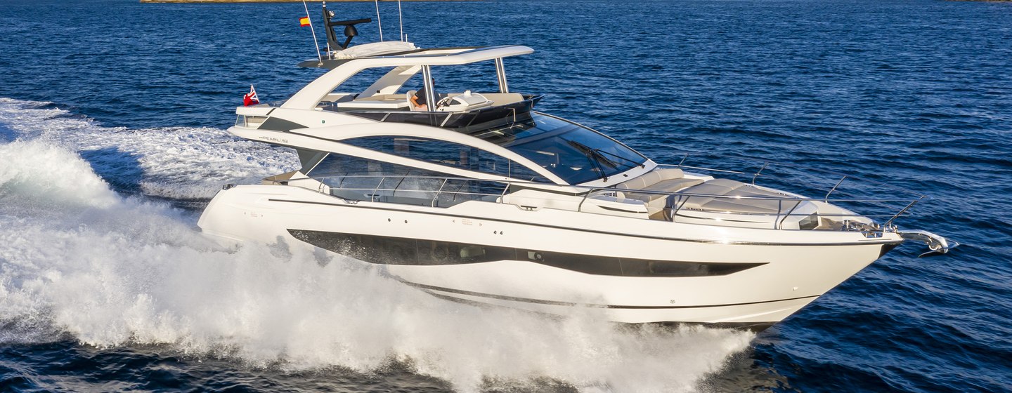 Pearl 62 flybridge yacht underway, surrounded by sea and distant cliffs