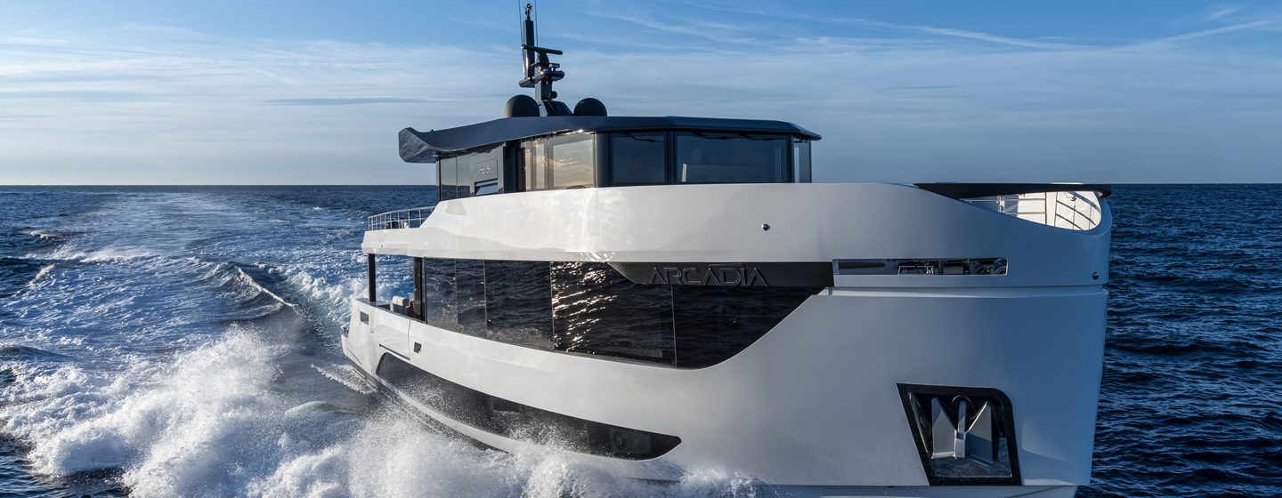 Arcadia Yachts A96 shown in running shot just above water level towards starboard bow and along side profile, moderate sea, bright day, creating wake along side profile