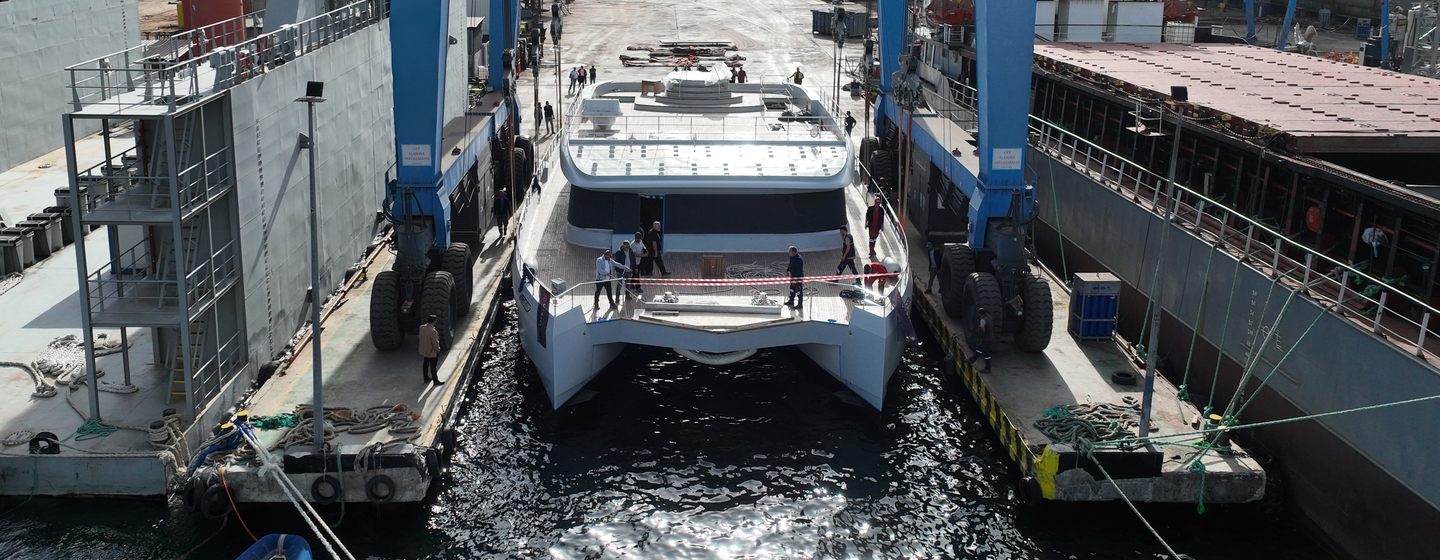 Catamaran Muzoon being lowered into water at launch