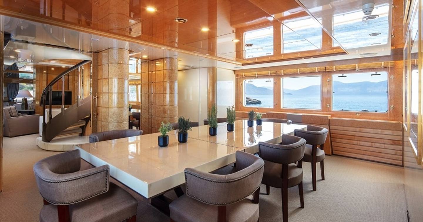 Feadship Superyacht Kassandra's first dining area with brown chairs and marbled table 