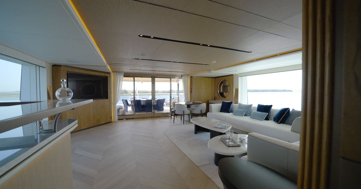 Skylounge aboard the Gulf Craft Majesty 145 with curved seating, panoramic windows and aft deck access