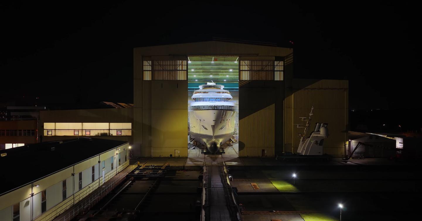 Superyacht Boardwalk leaving Lurssen shipyard at night before launch