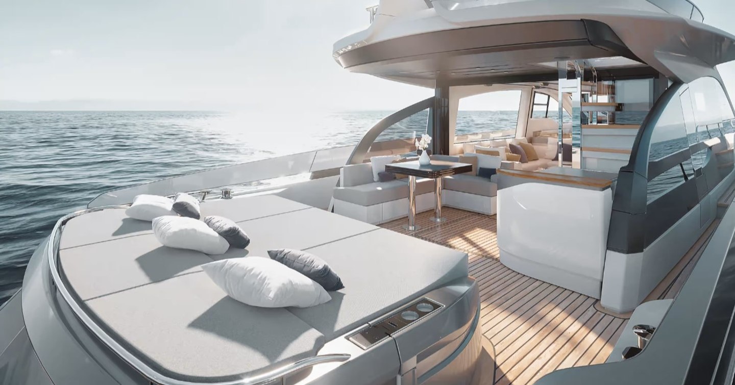 Overview of the aft deck onboard the Azimut S7 Mk2, sunpads in foreground with dining area visible in background. Surrounded by sea.