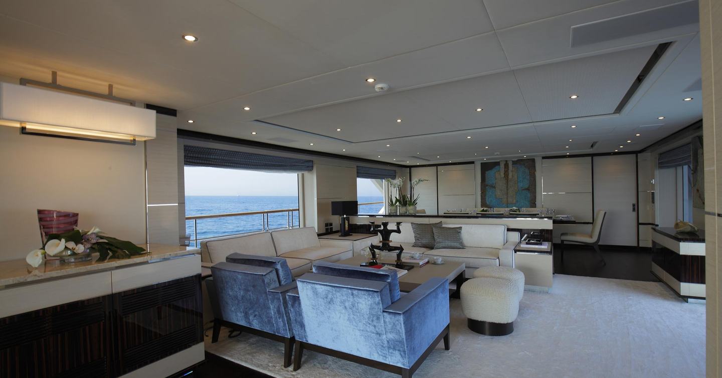 Overview of interiors onboard a Benetti motor yacht with cream seating and a wide window