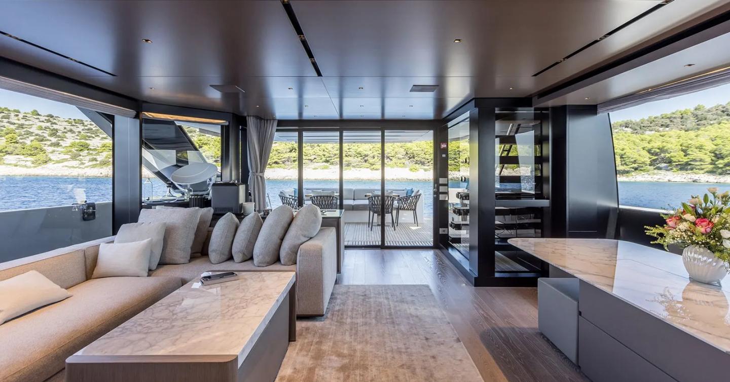 Motor Yacht JICJ main saloon with marbled coffee table and L-shaped grey sofa 