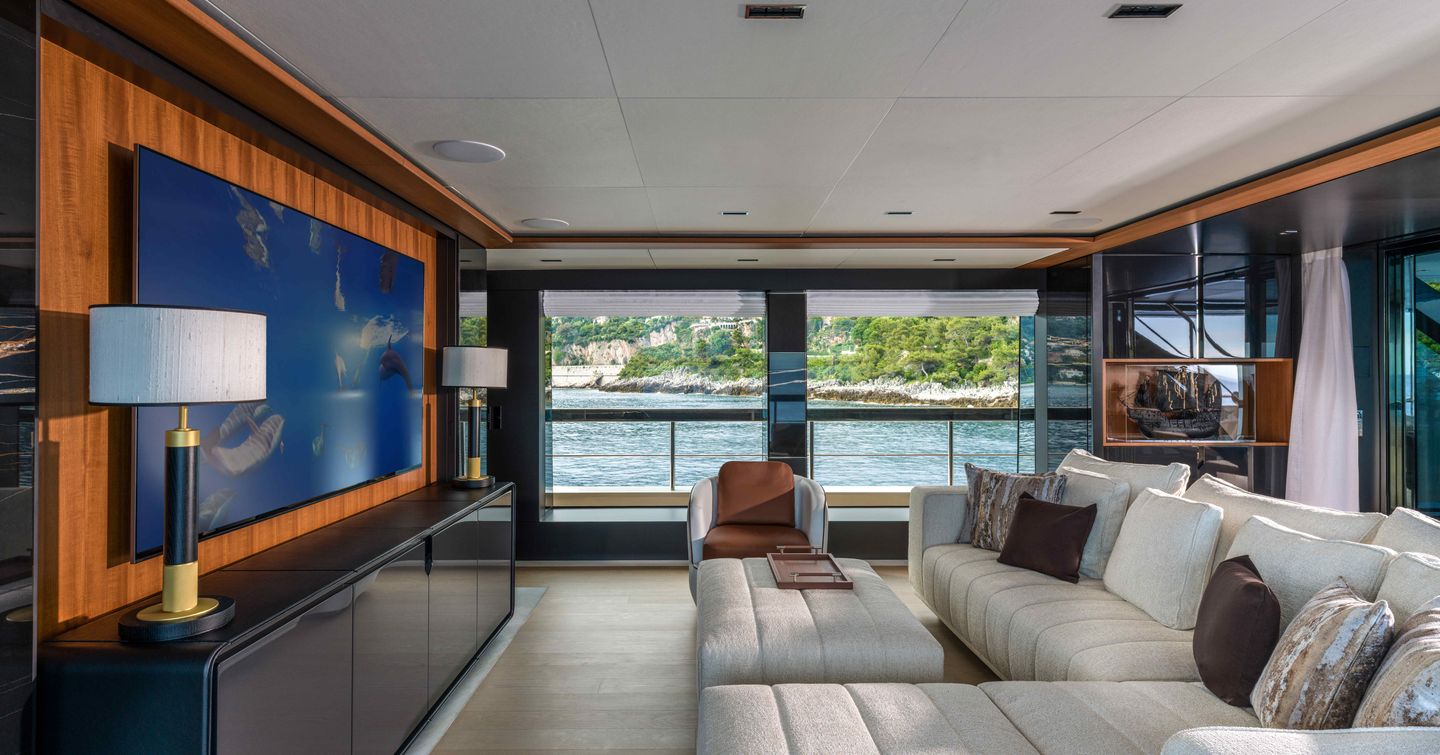 Riva 54Metri Superyacht Sairu skylounge with L-shaped white seating and mounted TV