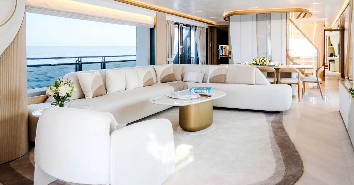 Gulf Craft Majesty 100 Terrace motor yacht main saloon with L-shaped white sofa and marbled coffee table 