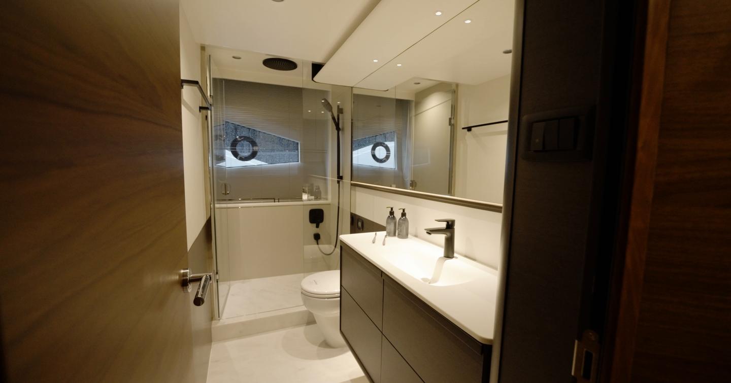 Princess S65 Mk2 owner's en suite bathroom with wide vanity, separate shower and hull window