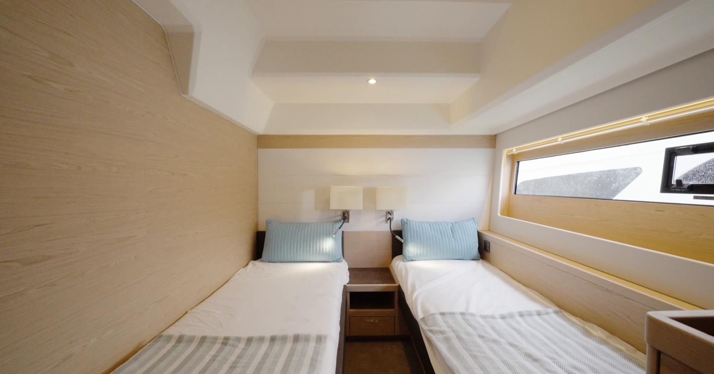 Beneteau Grand Trawler 63 twin guest cabin with single berths, hull window and bedside storage
