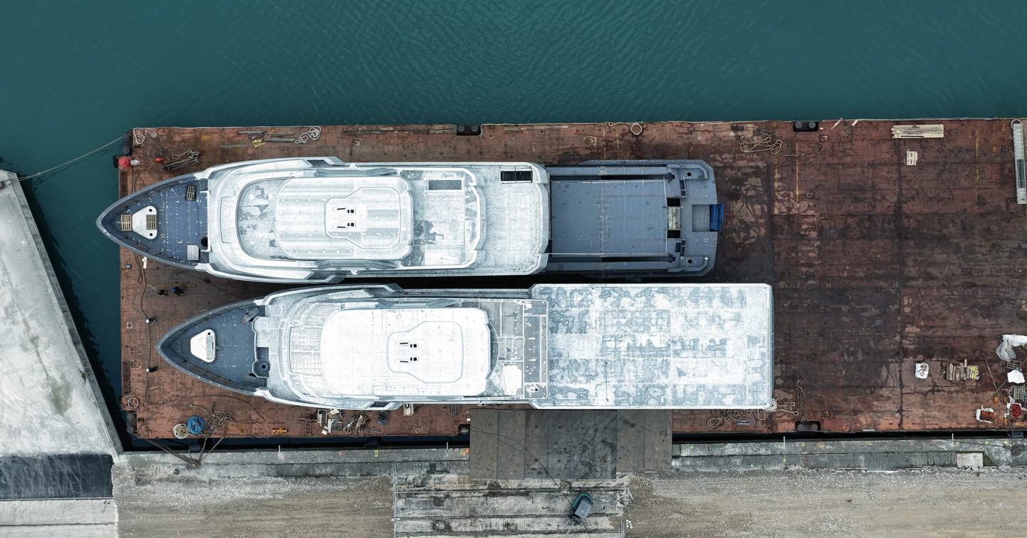 Aerial view of CdM Flexplorer 165 explorer yachts pre-outfitting next to each other on barge