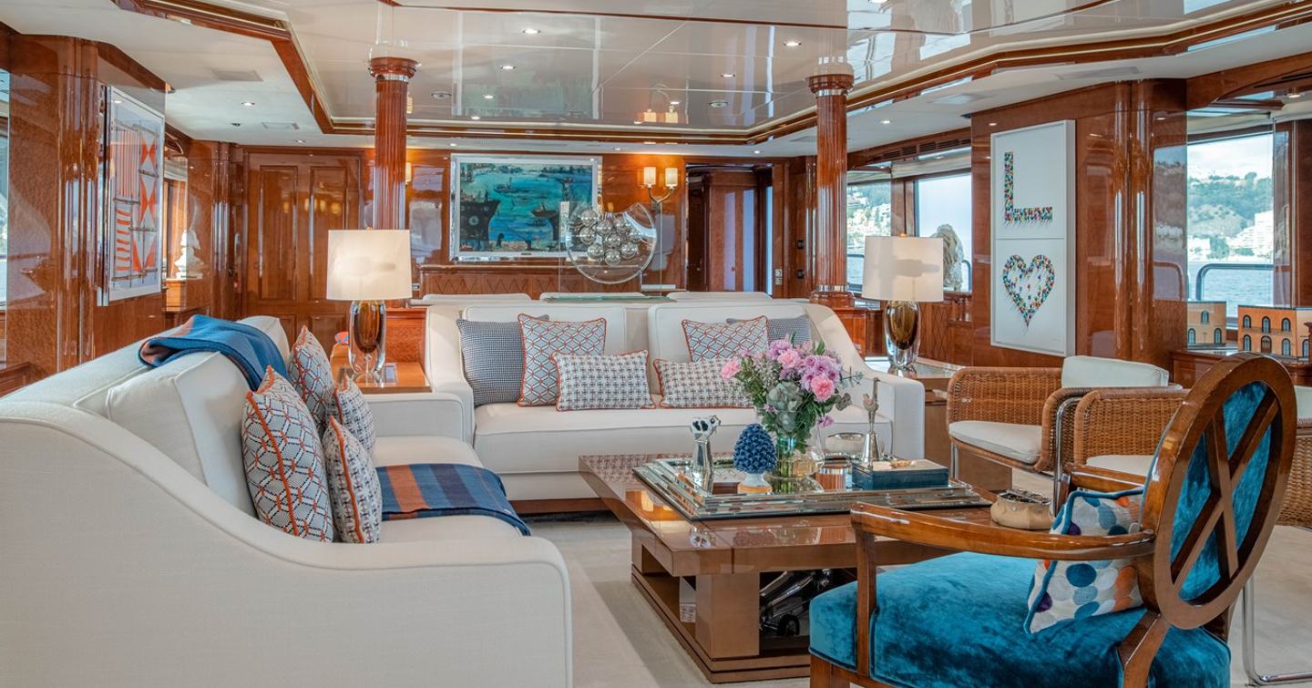 Superyacht Checkmate main saloon with white furniture and blue chair