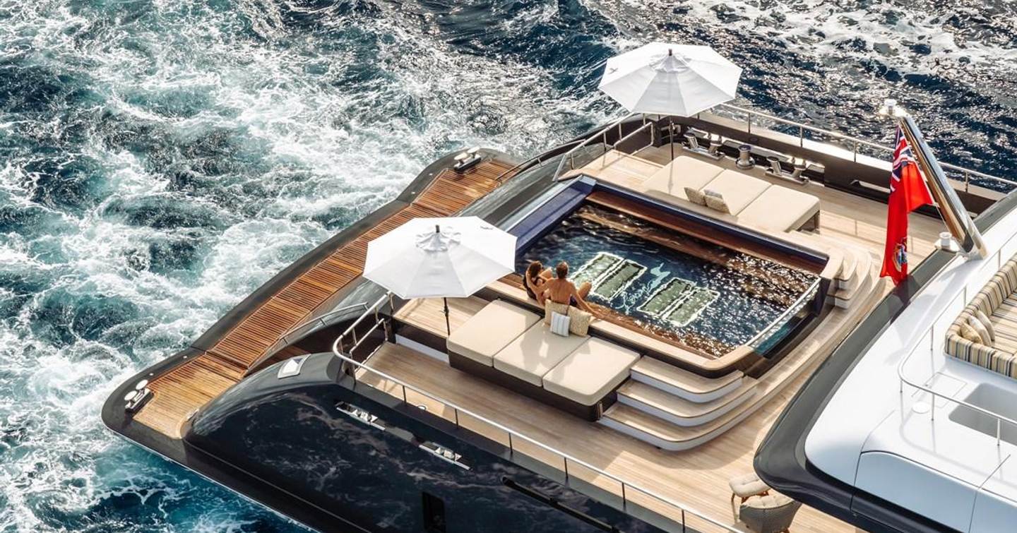 Beach club on motor yacht Loon with swimming pool, umbrellas and lounging areas