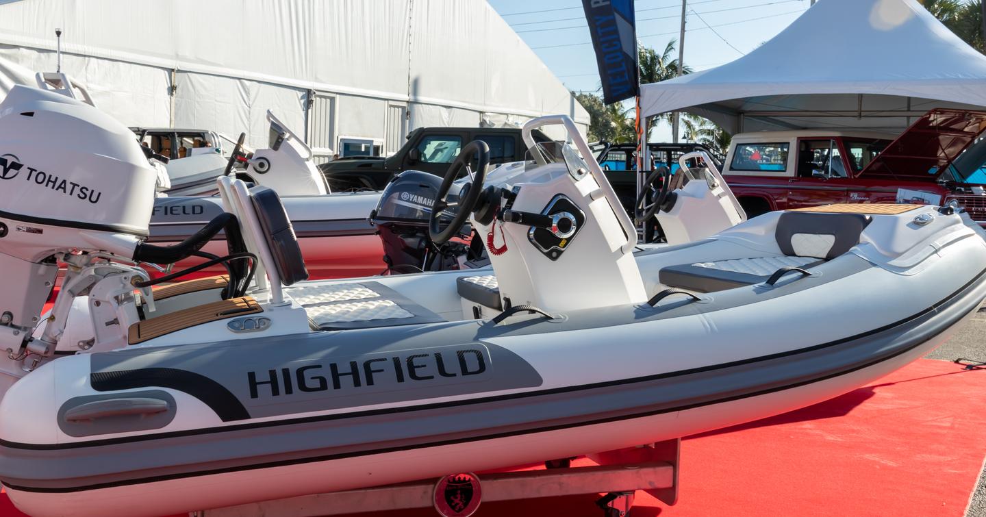 Highfield RIB tender on display at FLIBS, sat on red carpet surrounded by other tenders and a white gazebo