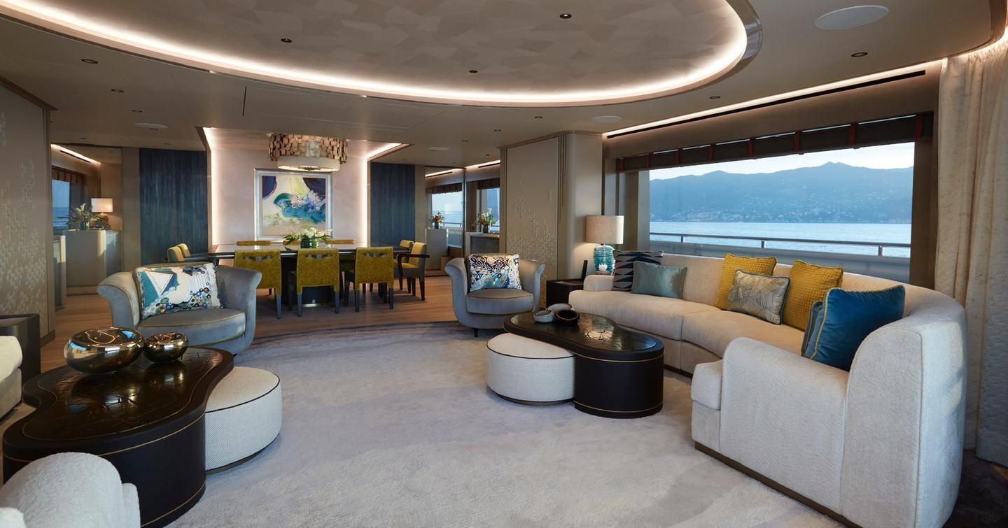 Superyacht Somnium main saloon with curved seating and yellow accents 