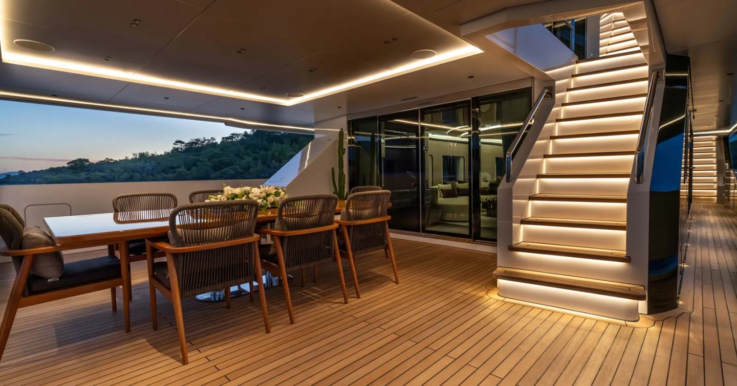 Superyacht Kasif exterior aft dining area and lit up stairway