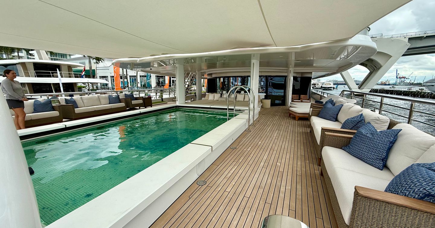 Main deck swimming pool on the Amels 242 Casino Royale surrounded by lounge seating and teak decking.