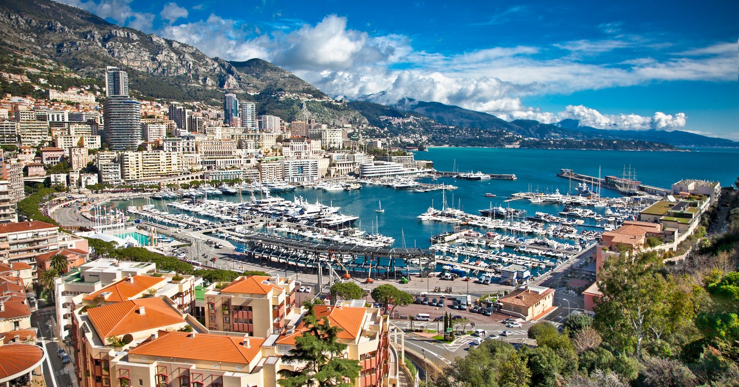 Overview of Monte Carlo and Port Hercule, many yachts berthed in marina with sea in background.