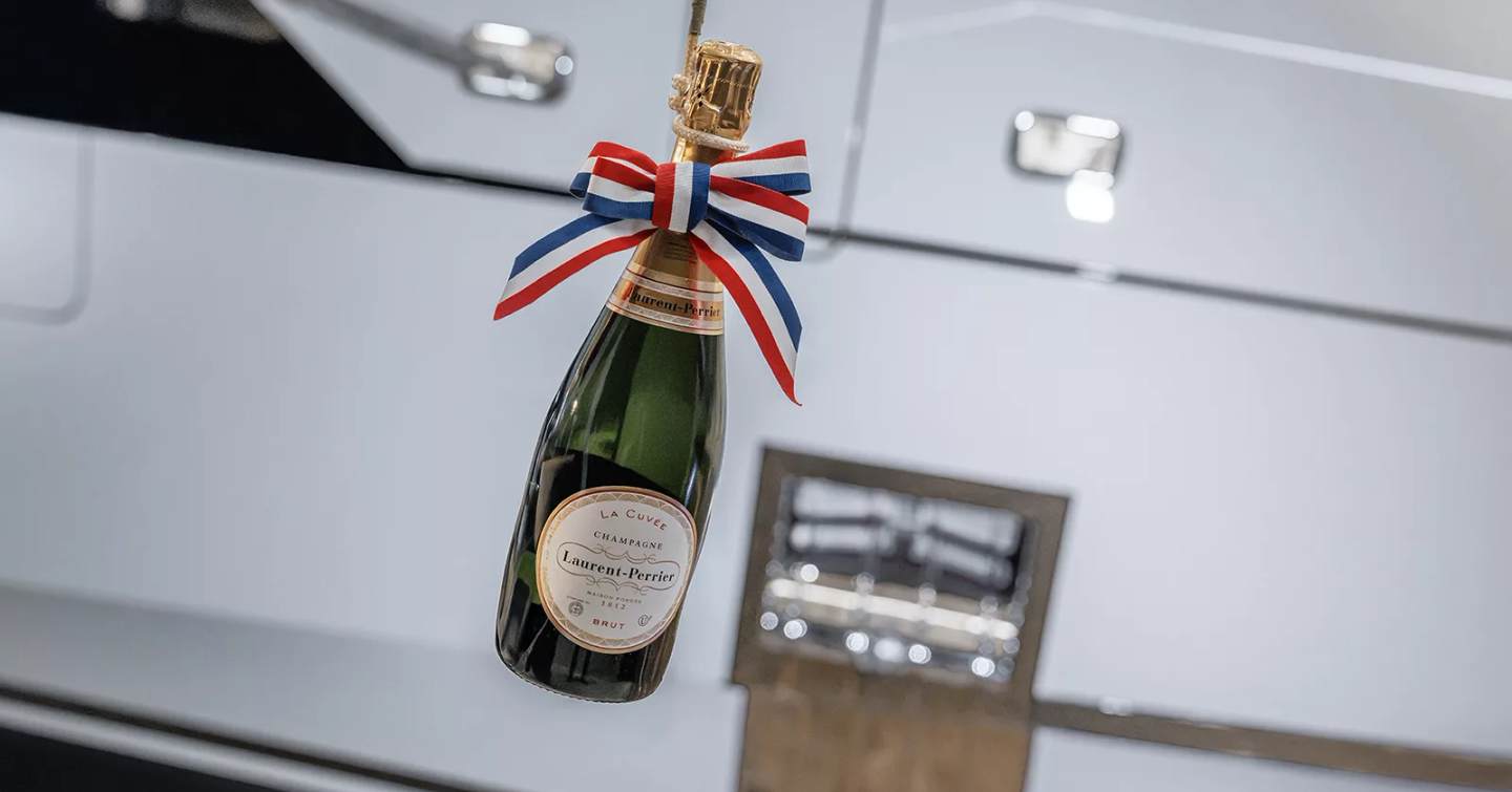 Champagne smashing on hull of superyacht Project Setteesettanta at launch