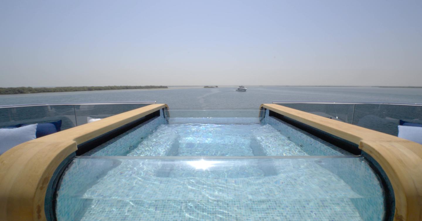 Glass-fronted infinity spa pool on the Gulf Craft Majesty 145 sundeck overlooking the stern