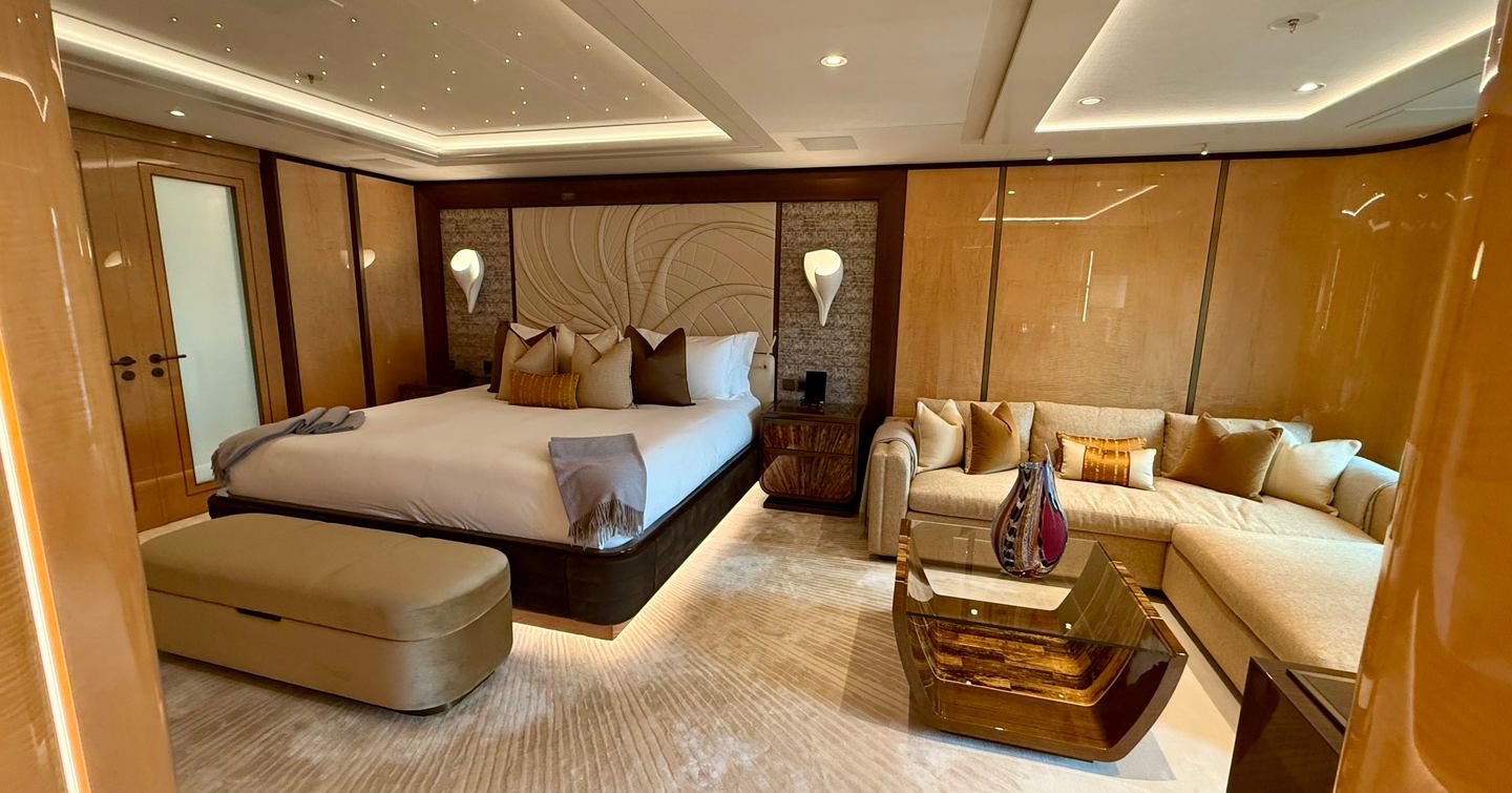 Forward VIP guest suite on the Amels 242 Casino Royale with double bed, sofa seating area and decorative headboard.