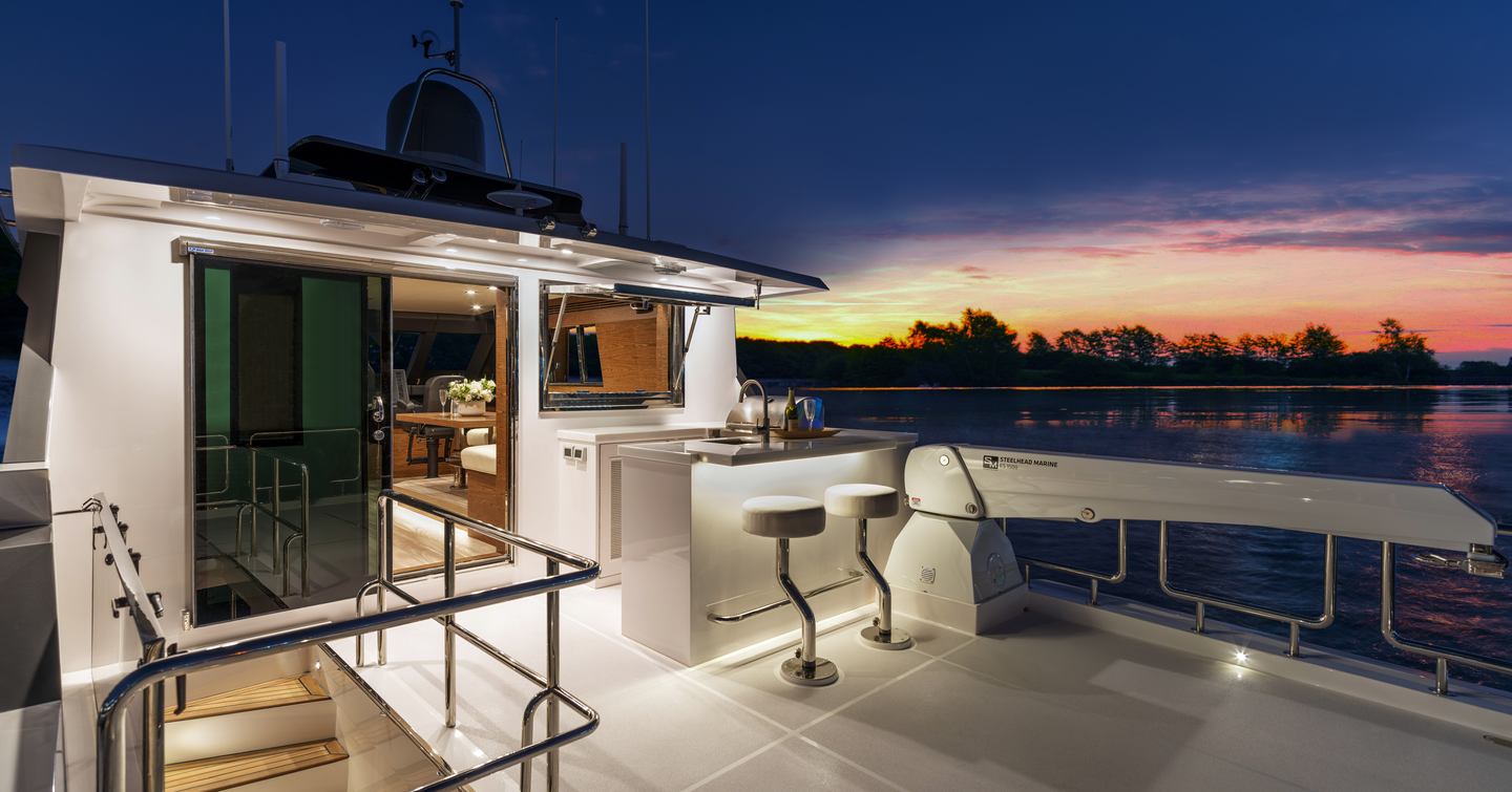 Horizon V77S Hull 13 motor yacht upper aft deck at dusk with small bar area 