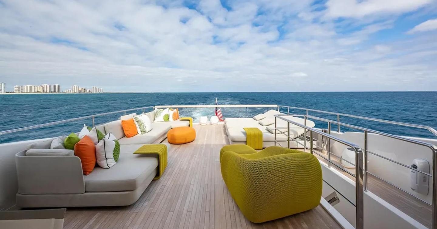 Motor yacht Xwave's aft upper deck with seating and sunpads