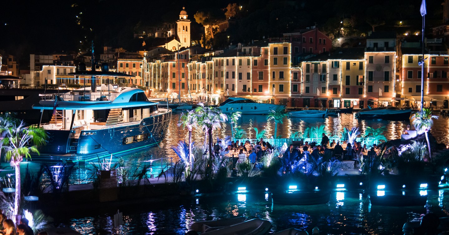 Azimut Magallano 25 at anchor during the night at Portofino, surrounded by illuminated yachts with blue lighting