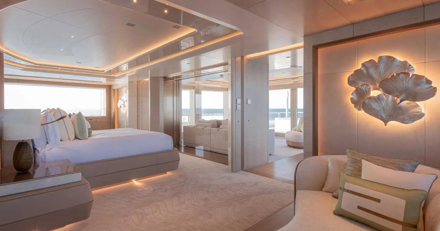 Overview of the master cabin onboard superyacht H3, central berth facing forward with a lounge area visible.