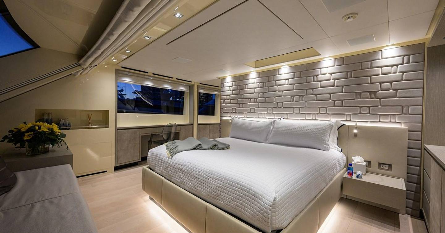 Owner's cabin on board motor yacht Phoenix with spacious bed, a desk and storage