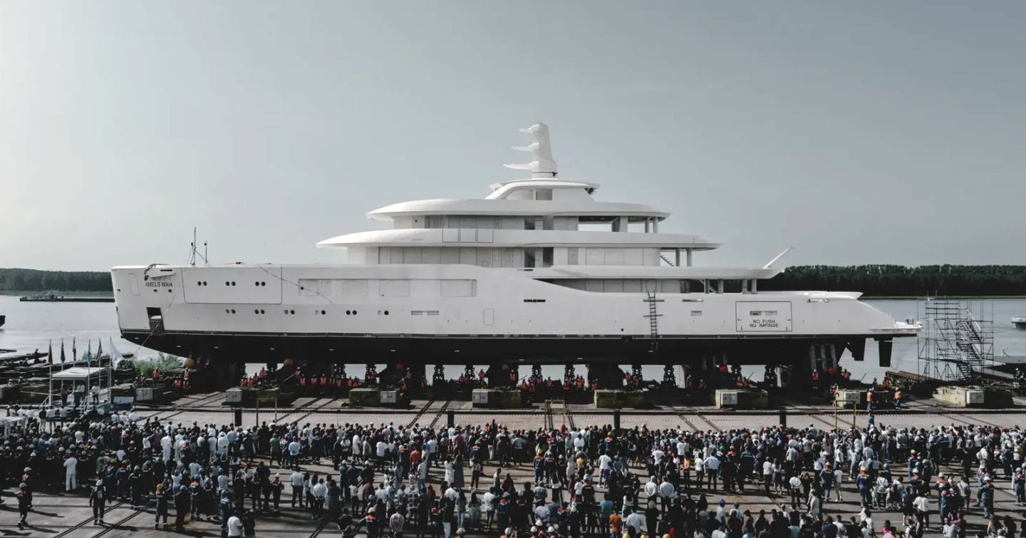 Superyacht 8004 at launch on wheels with Damen Yachting and Amels workers onlooking