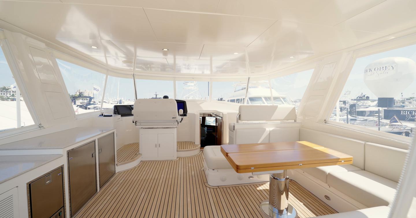 Fleming 85 enclosed flybridge with helm station, dining area and panoramic views