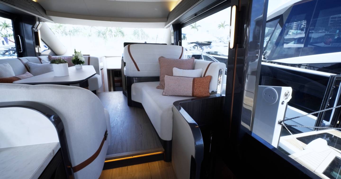 Galeon 520 Fly main deck saloon with open balcony and large sliding doors connecting cockpit and interior seating area