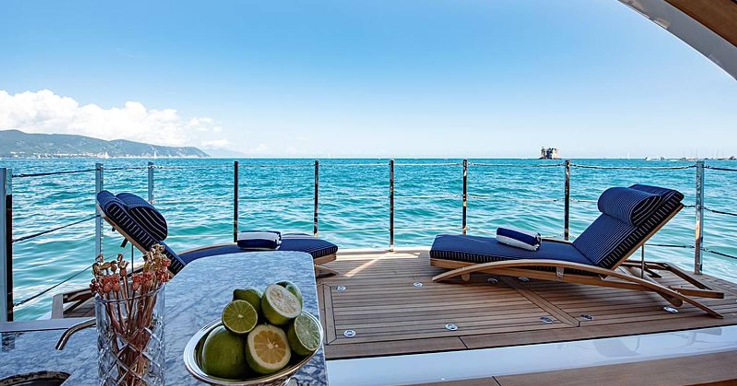 Side balcony onboard Sanlorenzo Lady Lena, with two sunloungers and a wetbar in port corner, overlooking sea